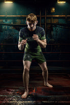 Nogi Jiu Jitsu superstar Jett Thompson in a wrestling stance wearing his custom Gaidama Fighter Jett rashguard and grappling shorts in dramatic lighting.