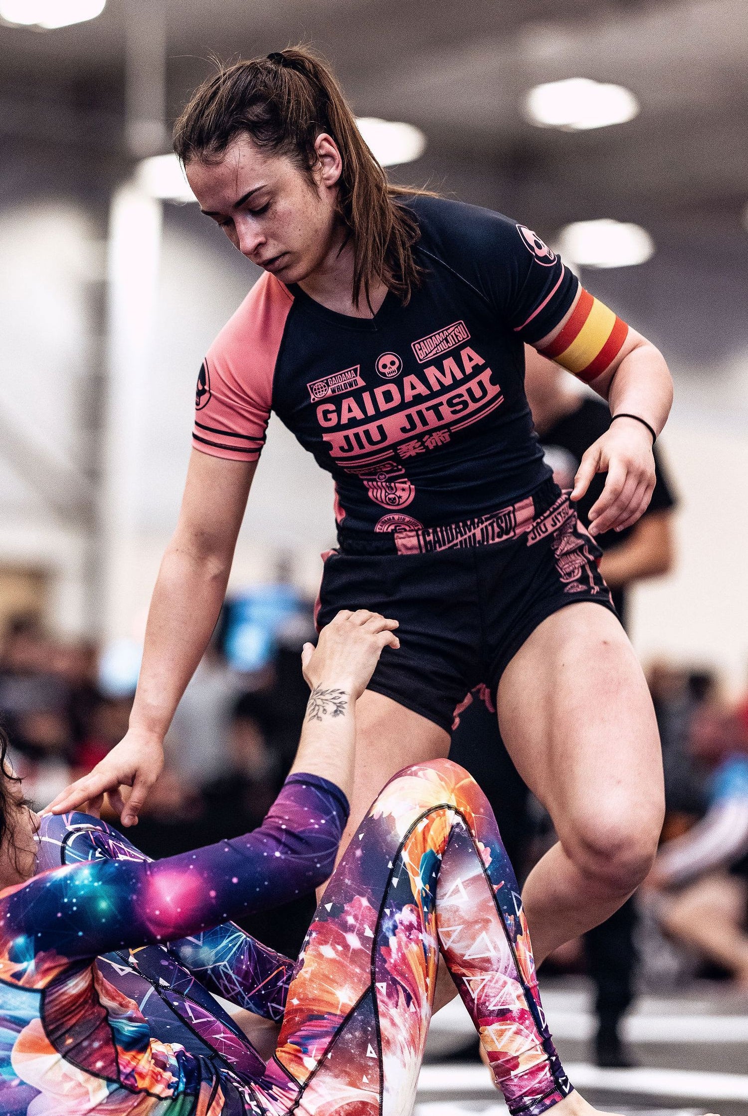 Woman wearing Gaidama's pink and black G Team BJJ rashguard and board shorts guard passing during an ADCC Open nogi Jiu Jitsu tournament.