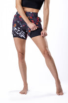 Women's beautiful Monarch butterfly-inspired pink, black, purple, and orange Jiu Jitsu board shorts, front view showing the built in compression shorts liner for full coverage BJJ shorts.